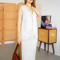 A woman wearing a blue sleeveless top and long matching skirt, a casual two-piece polyester suit.