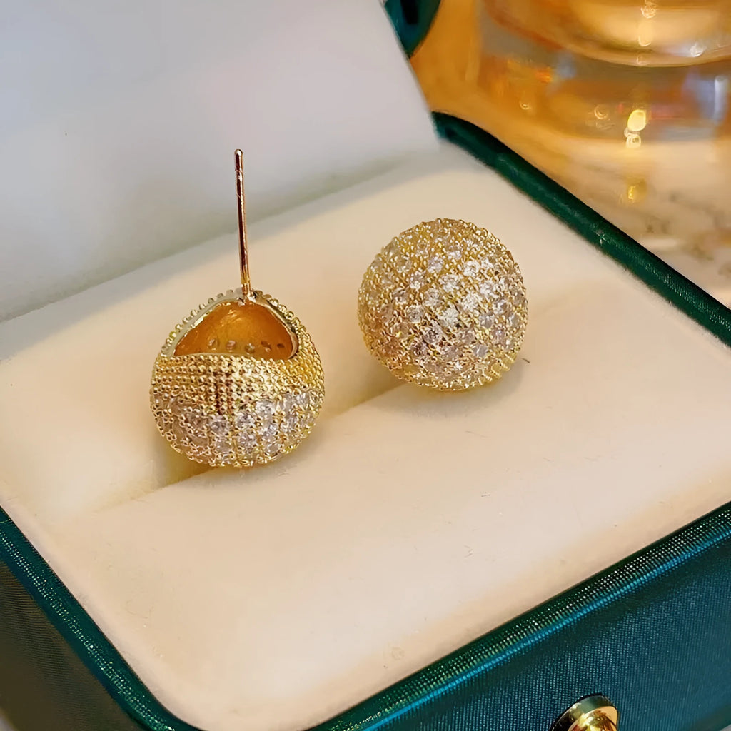 Gold geometric drop earrings with spherical elements and diamond detailing on clip-on backs