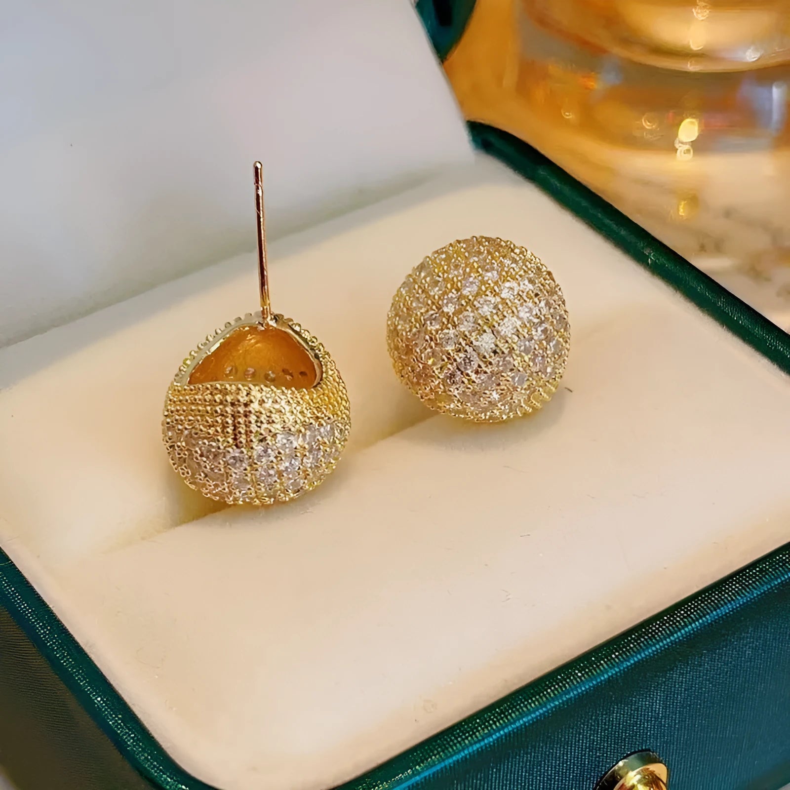 Gold geometric drop earrings with spherical elements and diamond detailing on clip-on backs