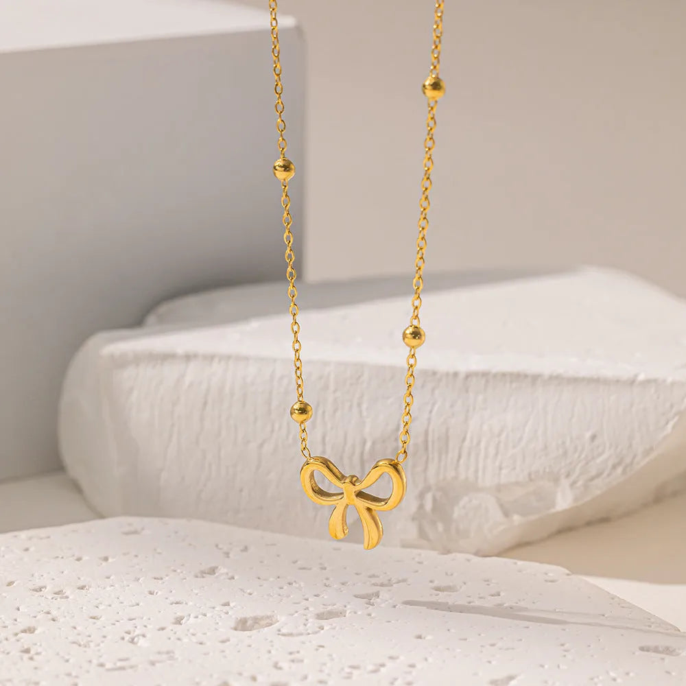 Gold bow necklace with cross chain links and adjustable 41-50cm length