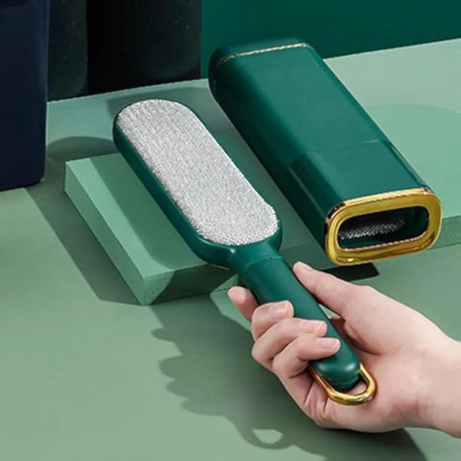 Blue, green and white pet hair remover brush with a reusable lint roller and storage box.