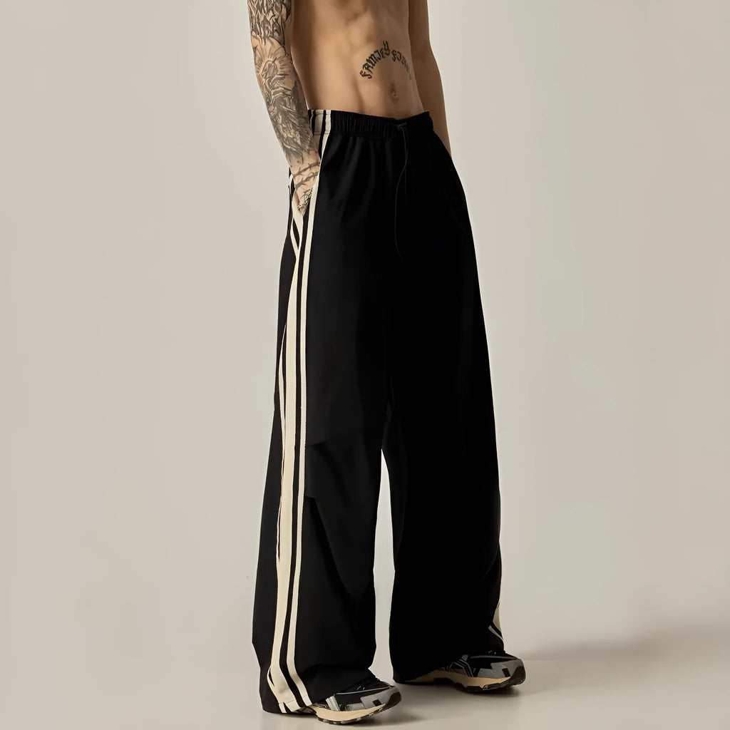 A man wearing black high-waisted wide-leg straight-cut casual climbing trousers.