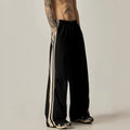 A man wearing black high-waisted wide-leg straight-cut casual climbing trousers.