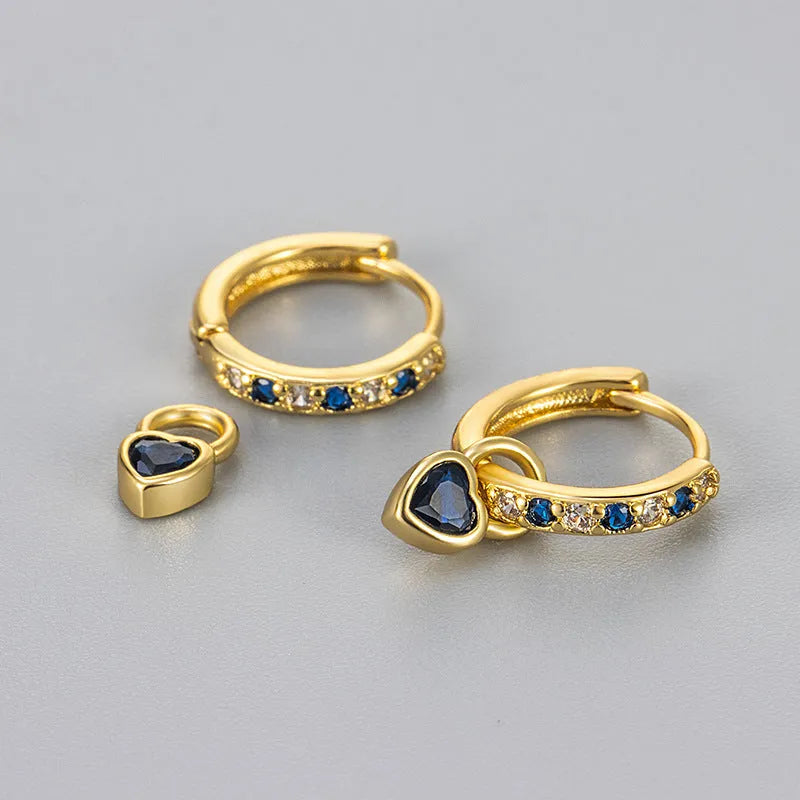 A pair of women's heart-shaped clip earrings with a coloured gemstone centre, available in gold or white gold colour metal.