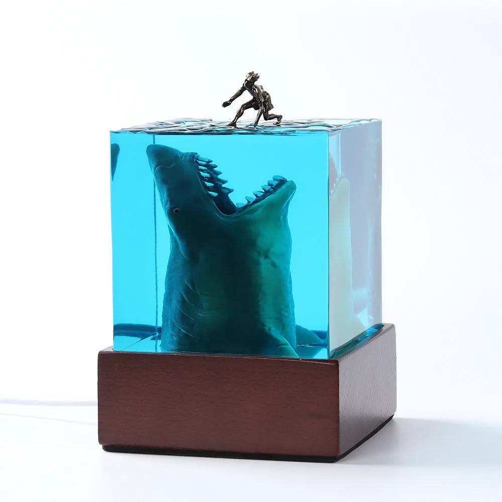 Epoxy resin shark surfer night light ornament on a desk, showing 5cm and 8cm size options.