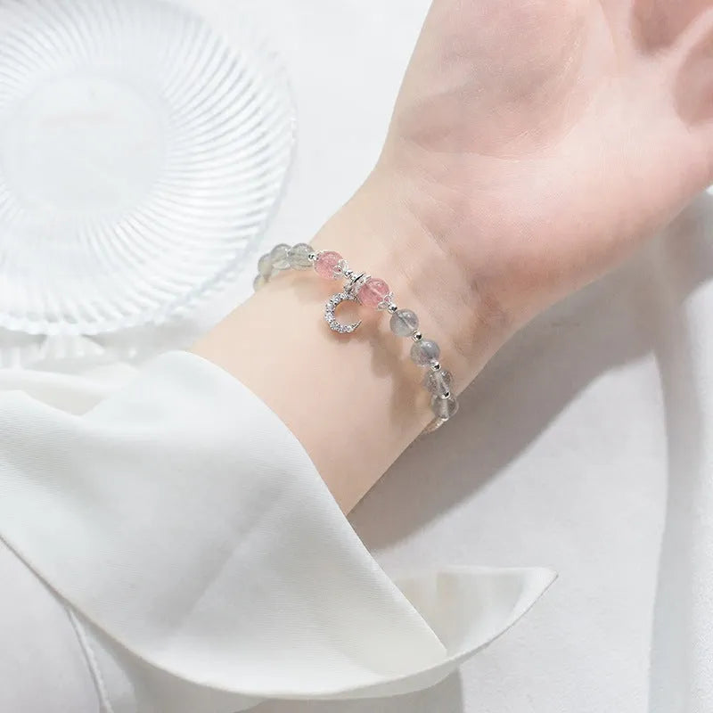 Natural moonstone bracelet with silver crescent moon charm on an adjustable chain.