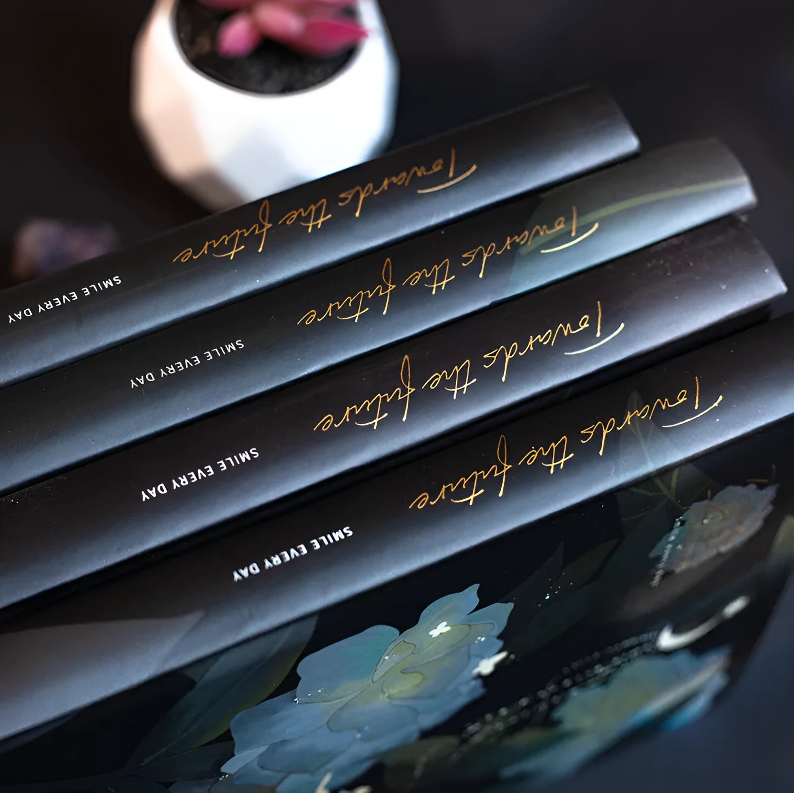 A5 spiral-bound notebook with a luminous holographic cover showing colour illustrations on the open pages.