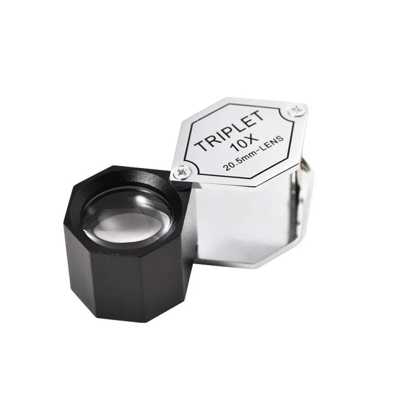 Handheld metal magnifying glass with optical lens for jewellery and stamp identification.