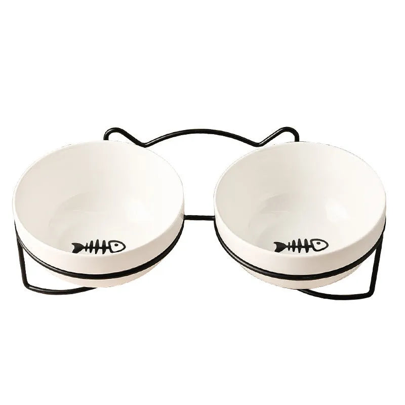 White ceramic pet bowl with cat paw design on a black metal stand with cat ear details.