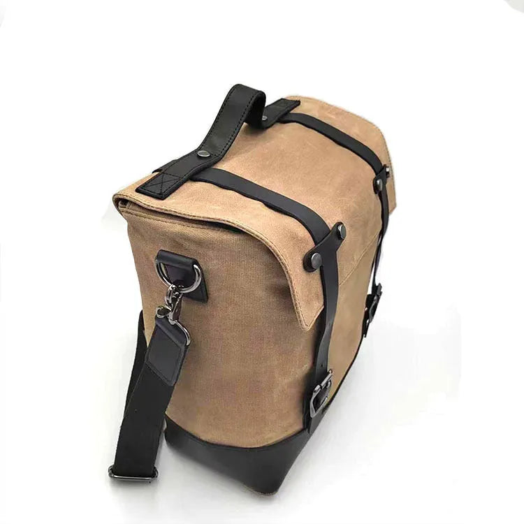 Black waterproof canvas motorcycle side pannier bag with leather trim mounted on a bike