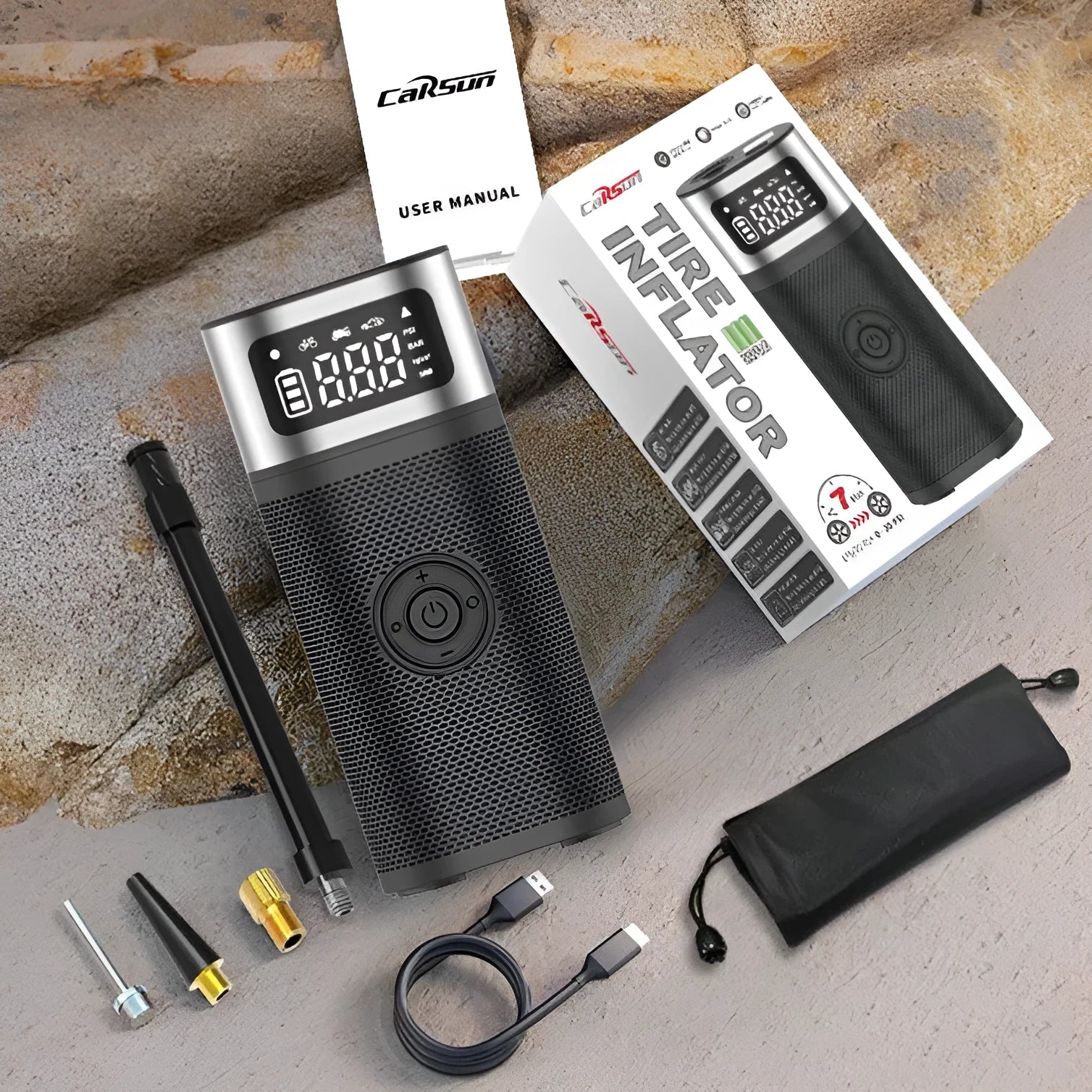 Black portable wireless smart vehicle air pump with USB-C cable and multiple nozzles on a grey background.