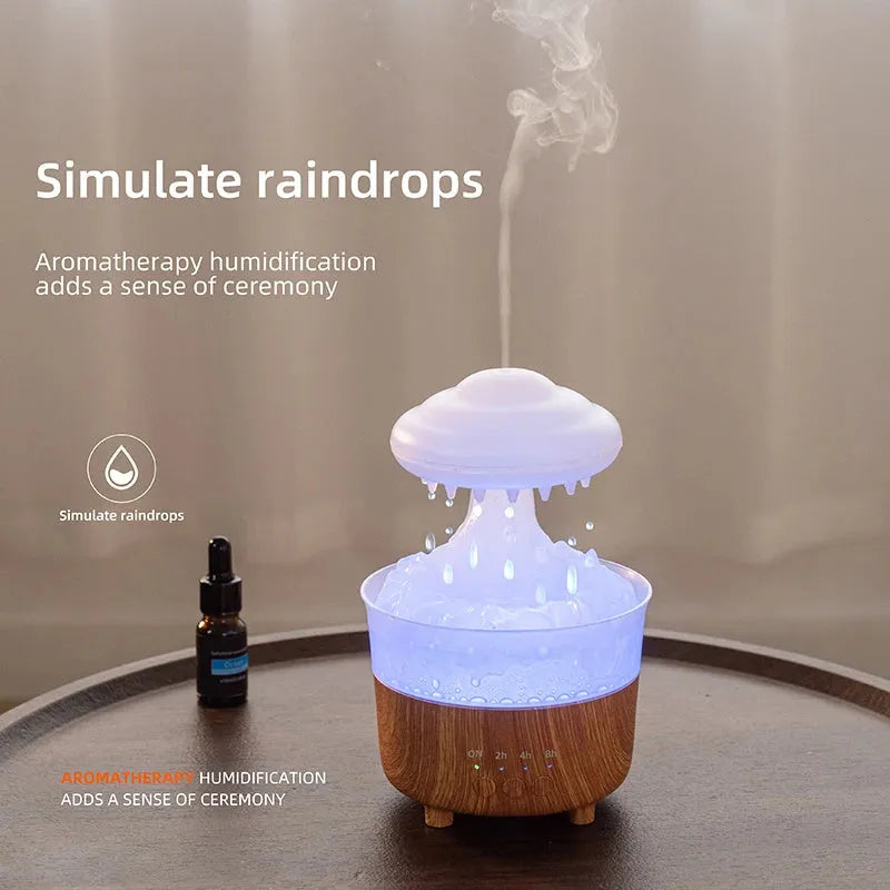 Wood grain green rain cloud shaped humidifier diffuser with coloured LED light on a table.