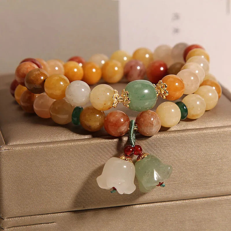 Natural green jinsi jade multi-layer bracelet for women with an orchid pendant charm on an elastic band.