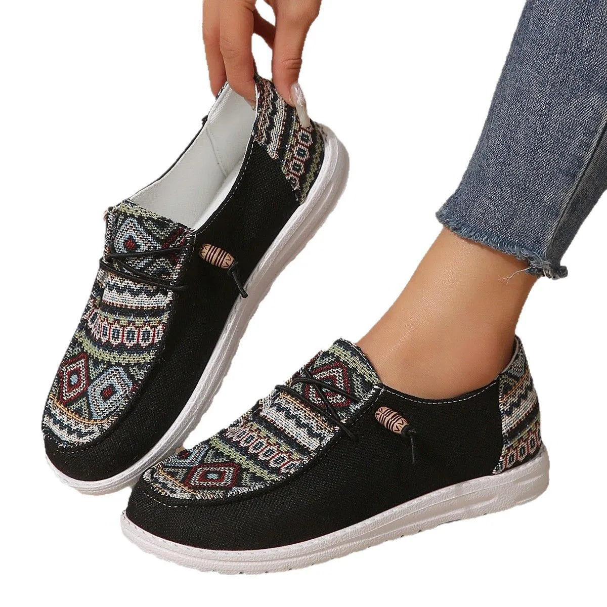 Women's black slip-on flat shoes with round toe and low-top profile on a neutral background.