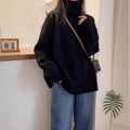 Women's loose grey turtleneck sweater with a thick, textured curling pile collar.