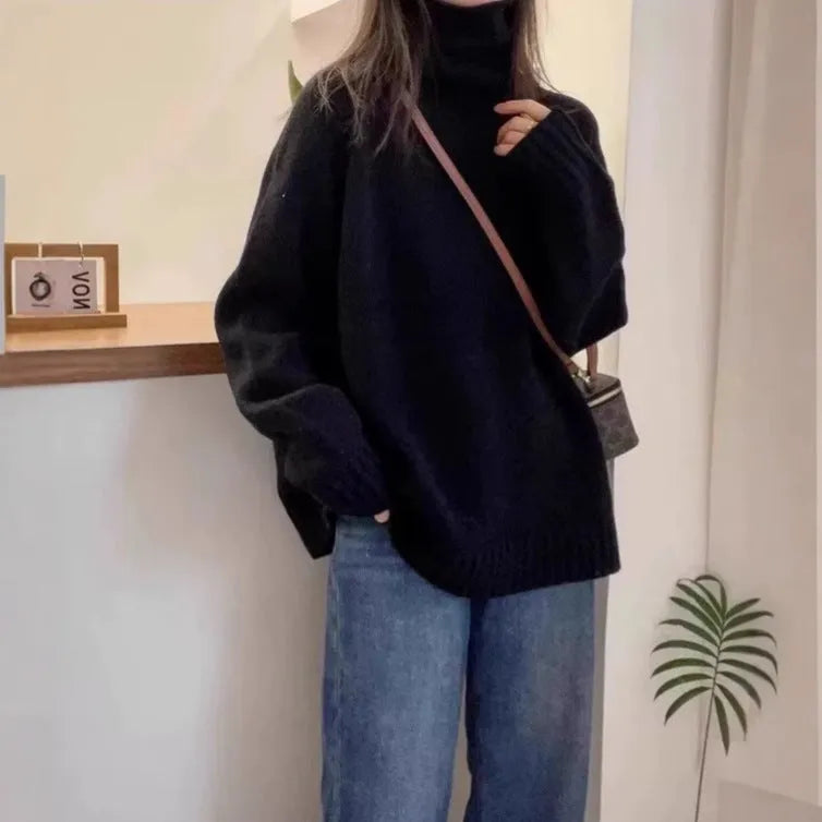 Women's loose grey turtleneck sweater with a thick, textured curling pile collar.