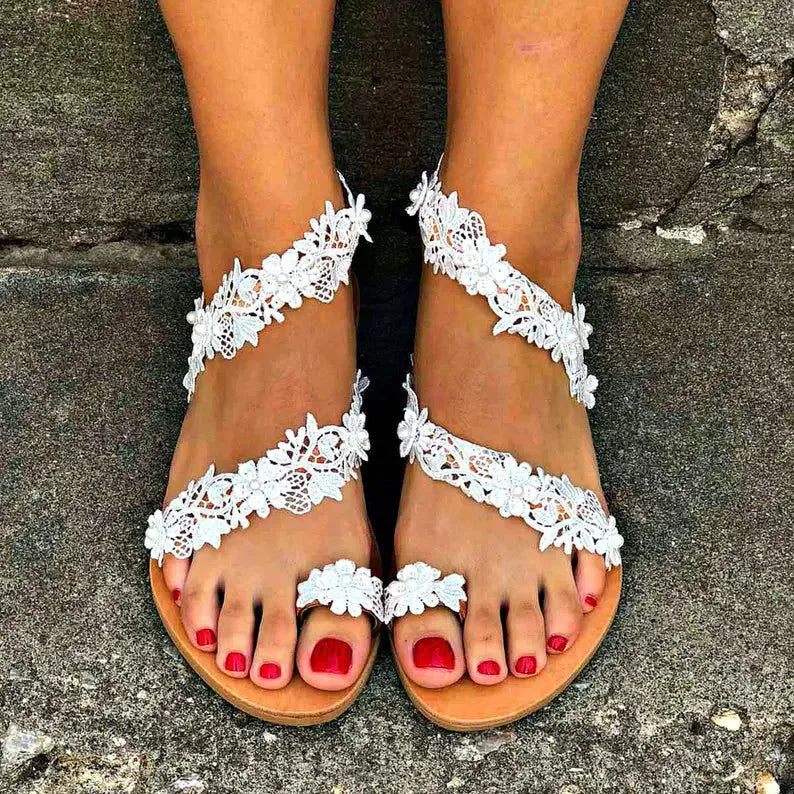 White women's flat sandals with rhinestone flower decoration on patent leather upper