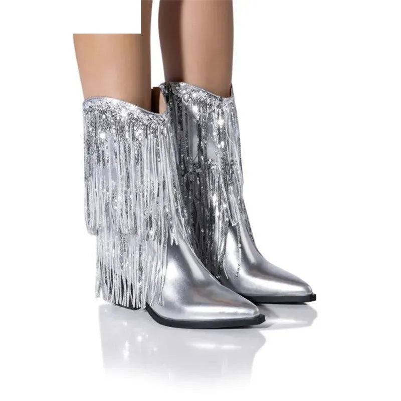 Women's black chunky heel tassel boots with pointed toe and super high stiletto heel on a plain background.
