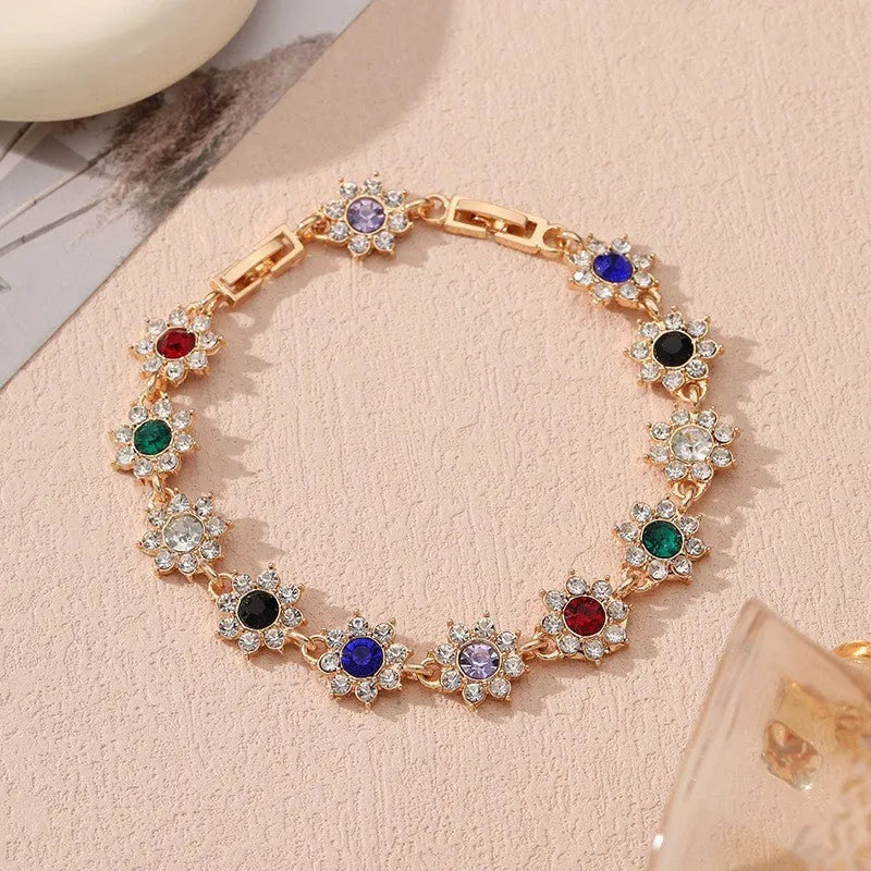 Electroplated zinc alloy bracelet with flower-shaped coloured gemstone charm in gold and silver colour variations