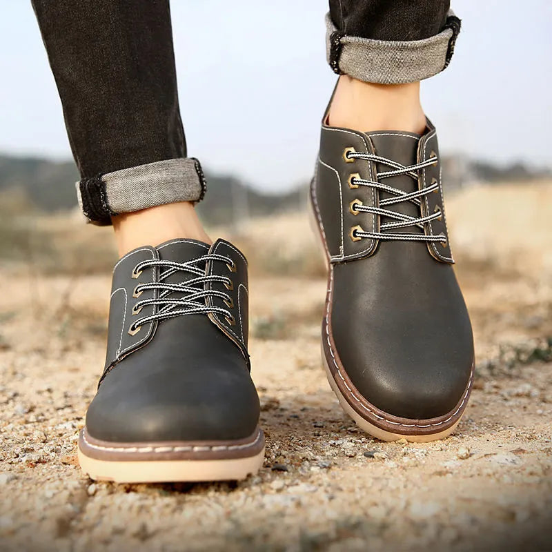 Men's black mid-top Tide British leather boots with a flat rubber sole on a neutral background.