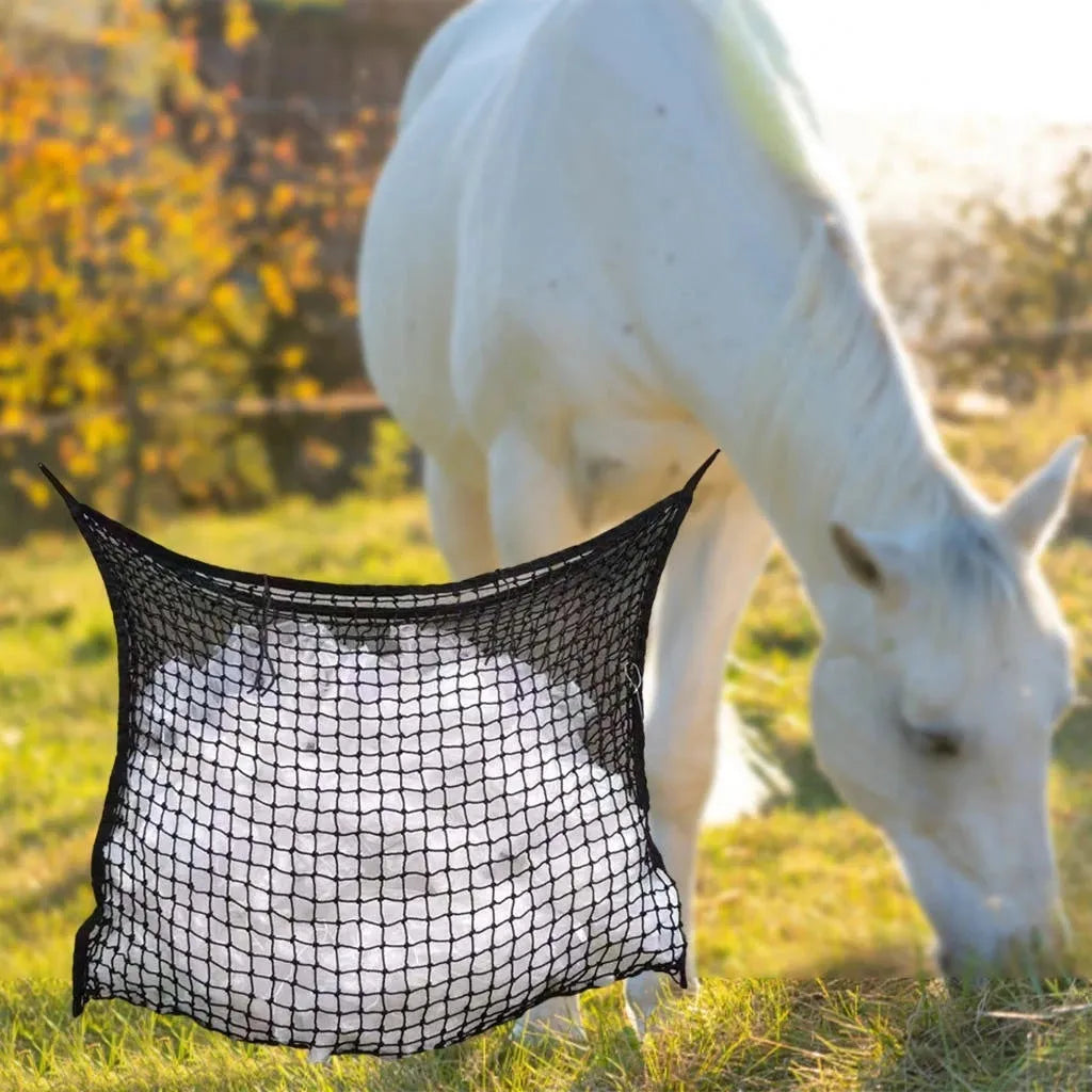 Black woven grid horse feeding bag hanging, filled with hay, for cattle or sheep.