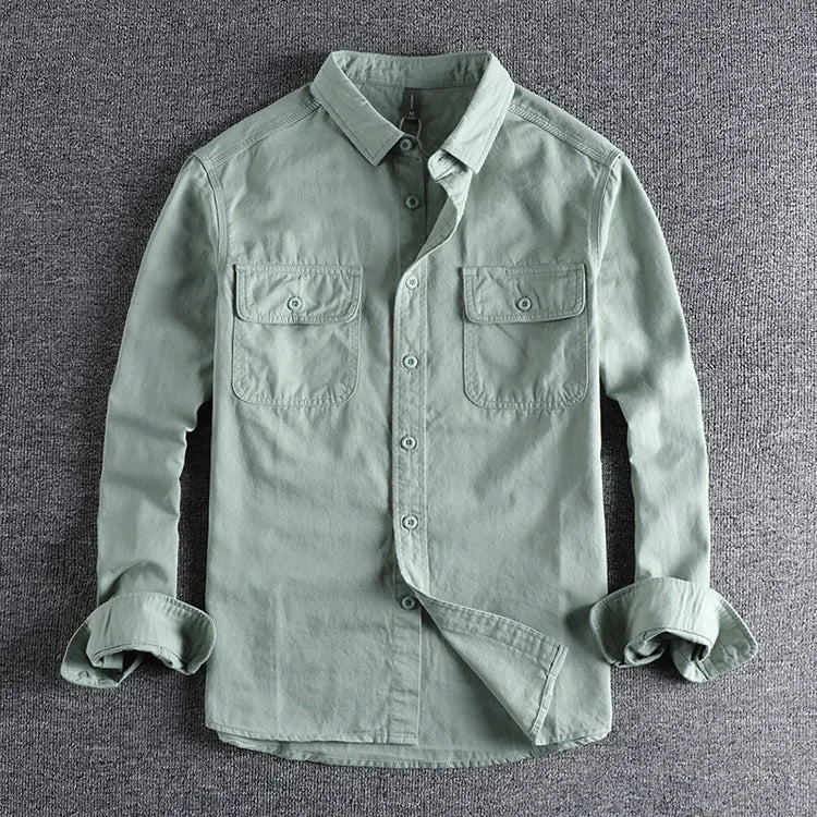 Man wearing a loose grey cardigan-style button-up shirt with long sleeves.