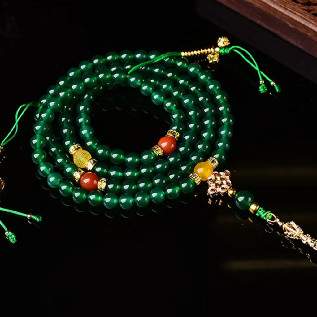 Natural green agate multi-strand bracelet with sliding knot closure on a wrist.