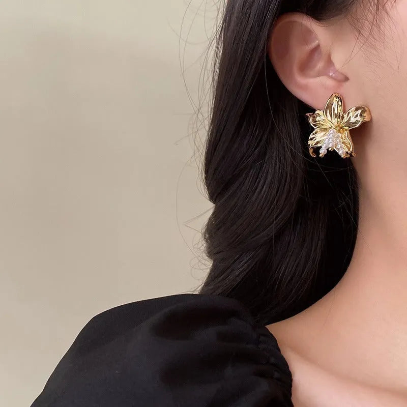 Gold H1795 flower earrings with exaggerated pearl accents on metal construction