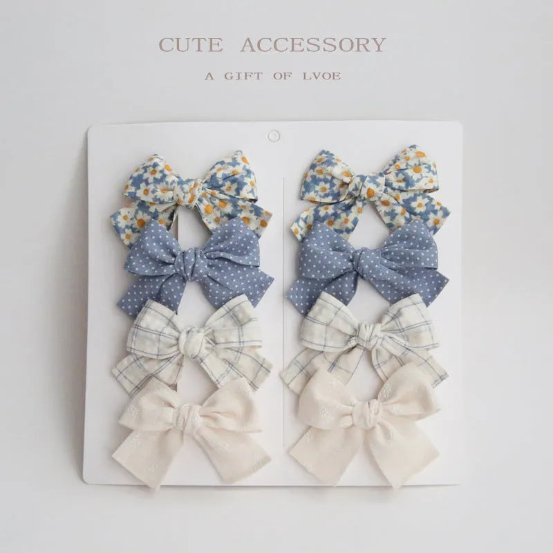 Children's fabric bow hairclips set showing dovetail design in multiple colour options