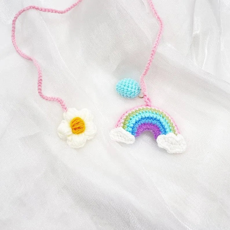 Handmade crocheted avocado flower car pendant in wool with rainbow colours hanging in vehicle
