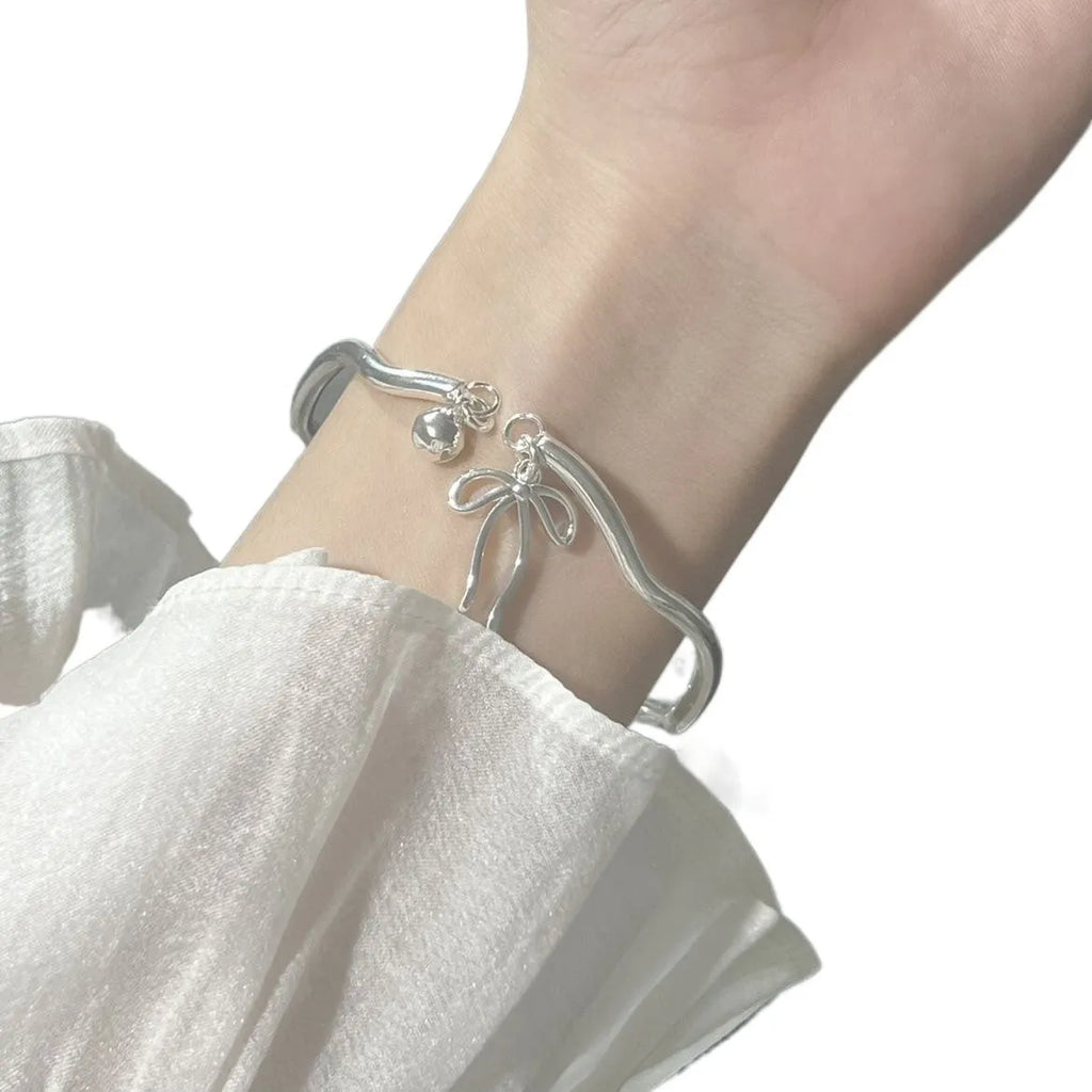 Silver adjustable bracelet with bow charm and bow bell opening clasp