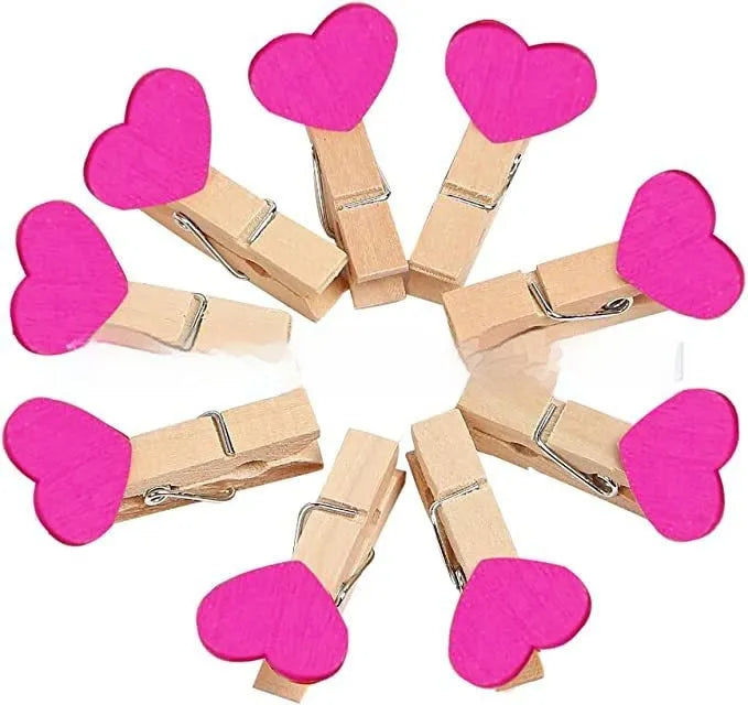 Five small solid wood heart-shaped clips in different colours showing handmade craft details