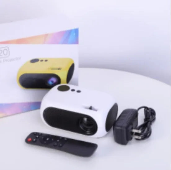 Compact gold or white M24 micro mini LED projector on a table with power adapter and AV cable.