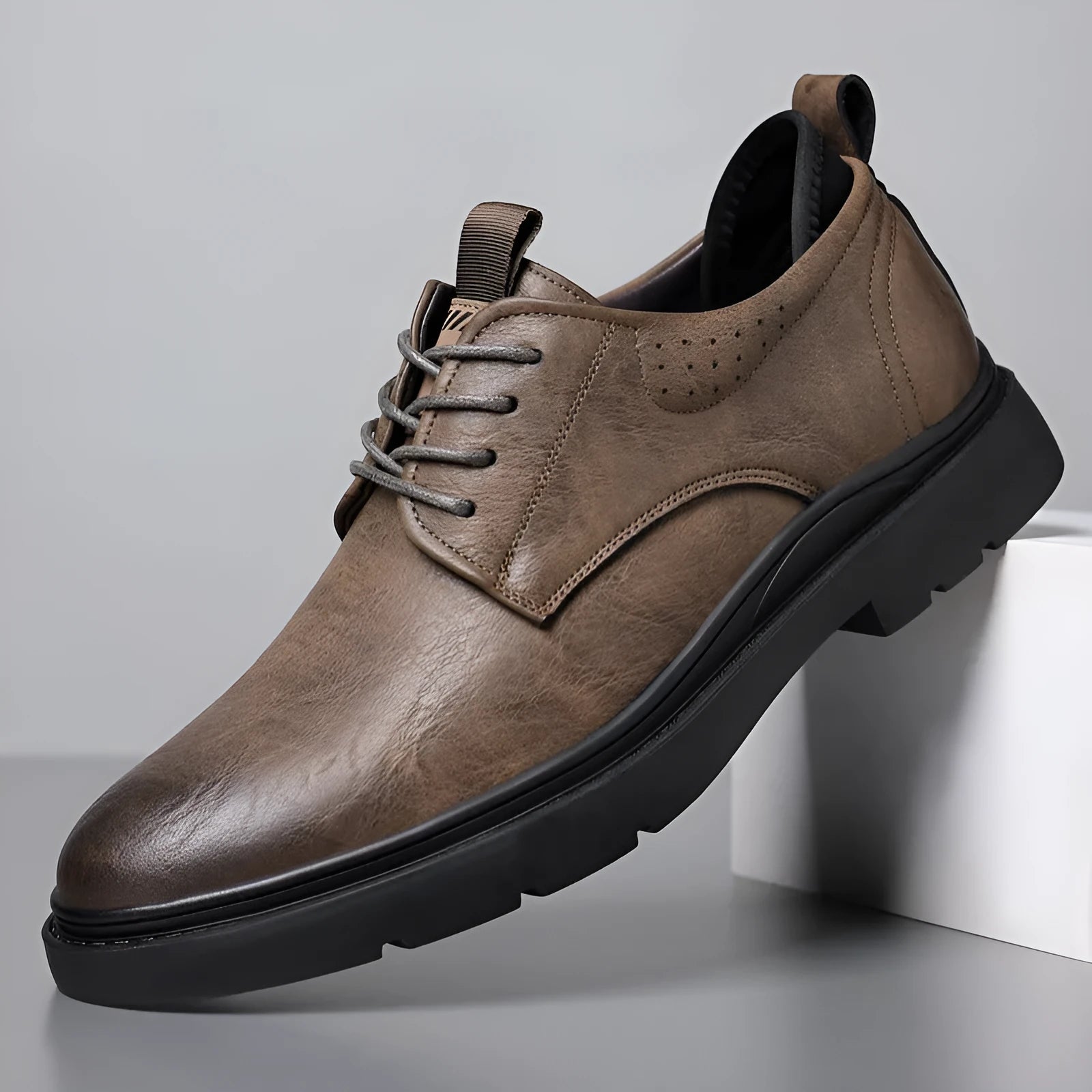 Men's black and brown leather casual sneakers with sewing line detail on the upper.