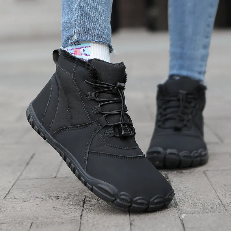 Unisex black waterproof snow boots with lace-up front and thick rubber sole on a snowy background.