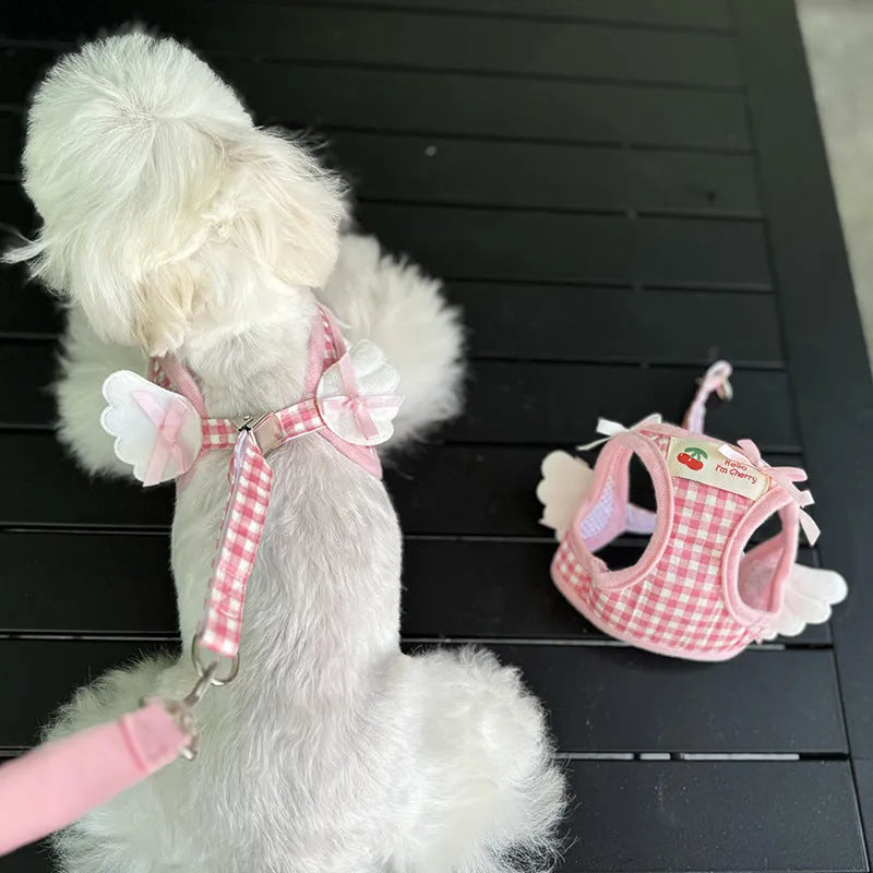 Pink and black small dog harnesses with a hand-holding rope connected at chest and back points.
