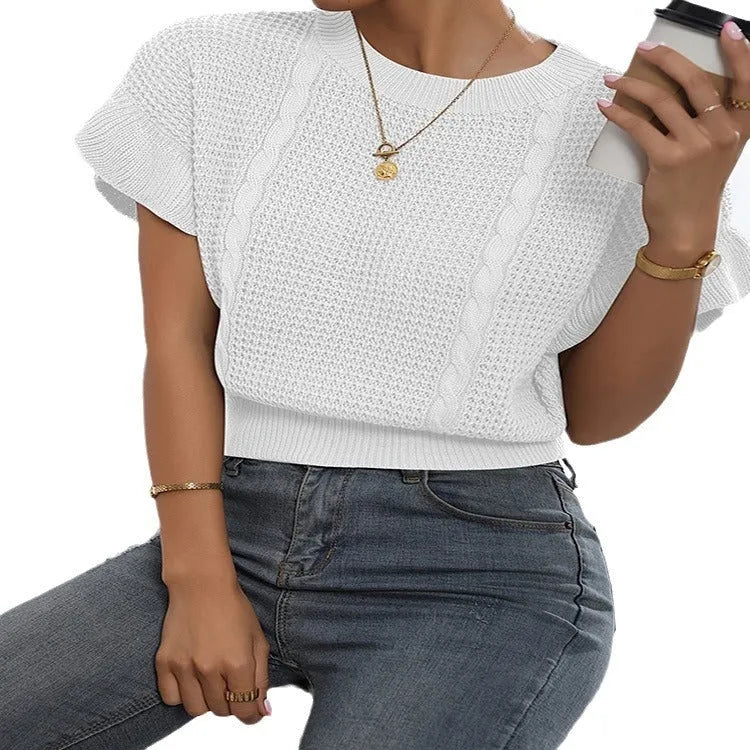 Loose-fitting white knitted pullover sweater with textured ruffled short sleeves on a model.