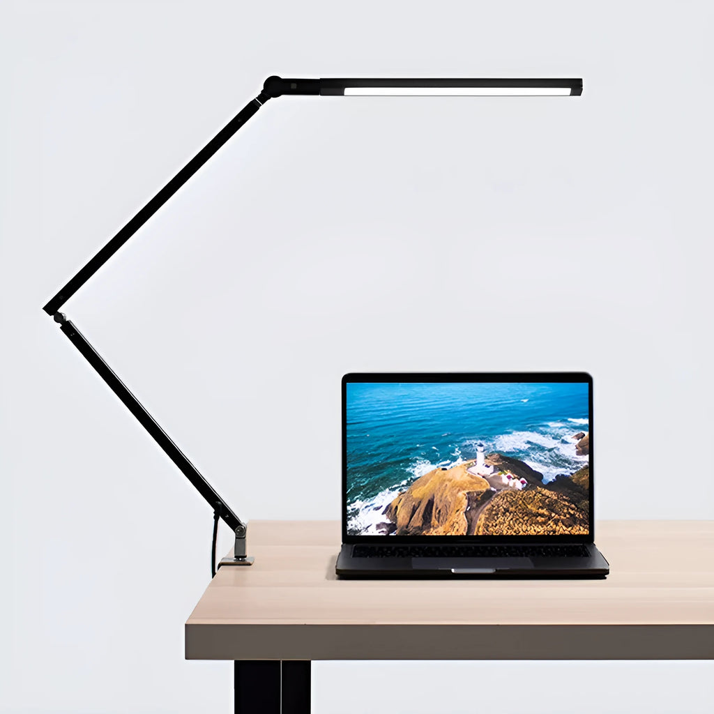 Black adjustable clip-on desk lamp with flexible arm and remote control on a wooden desk