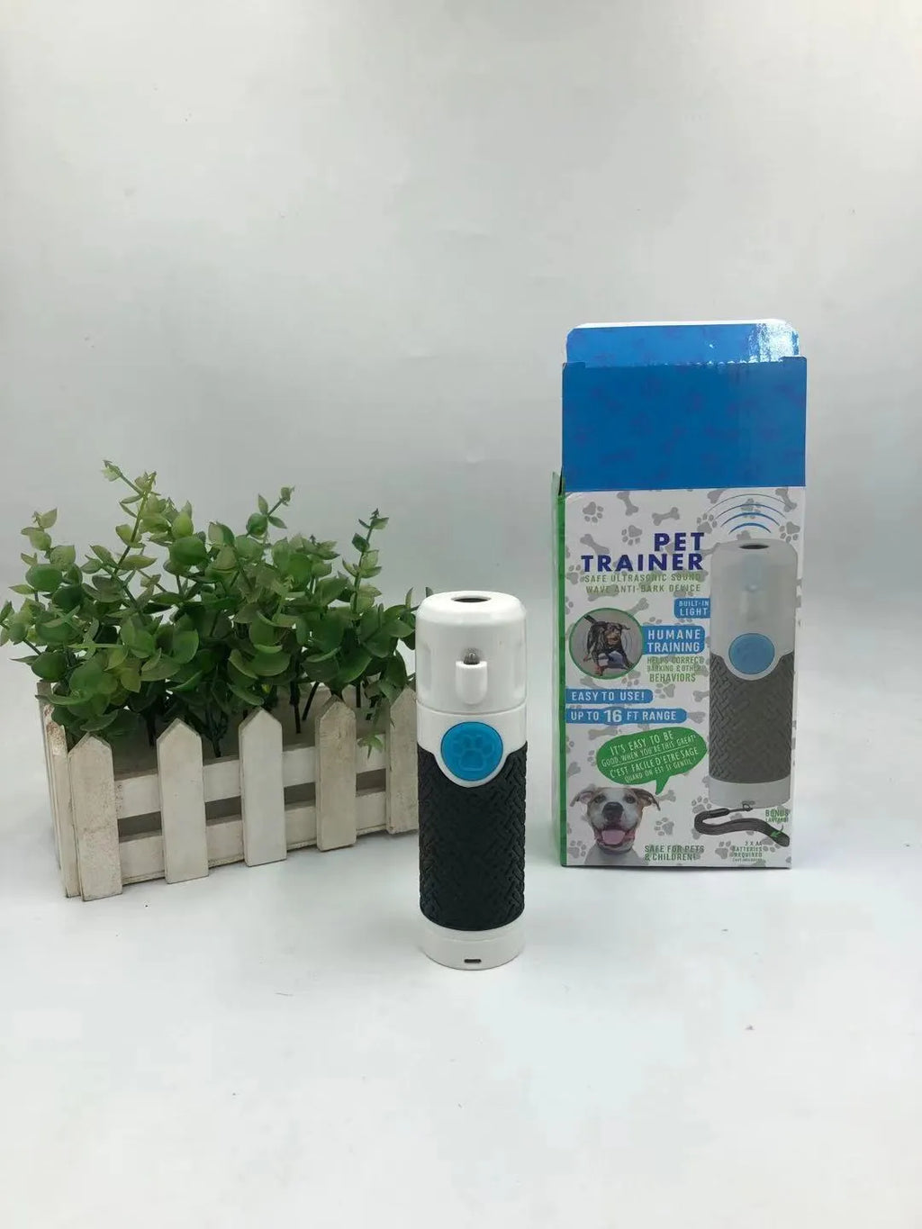White handheld ultrasonic dog trainer and bark-stop device on a plain background.