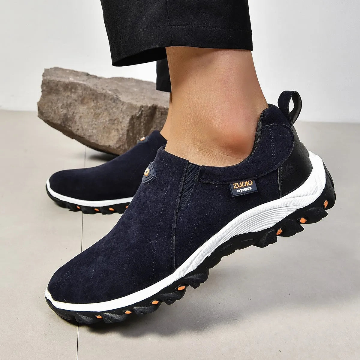 Men's grey slip-on shoe cover with round toe and rubber sole on a white background.