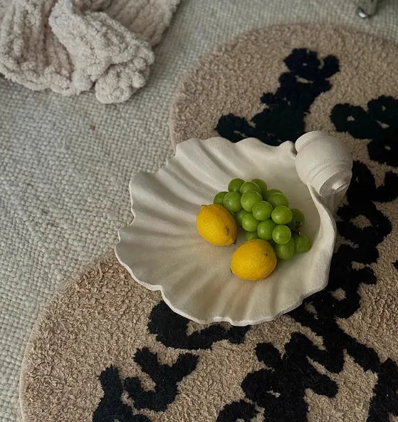 White resin simulation shell fruit plate ornament on a table