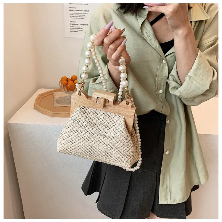 Women's woven straw shoulder bag with pearl chain detail in beige colour, showing interior organiser pockets.