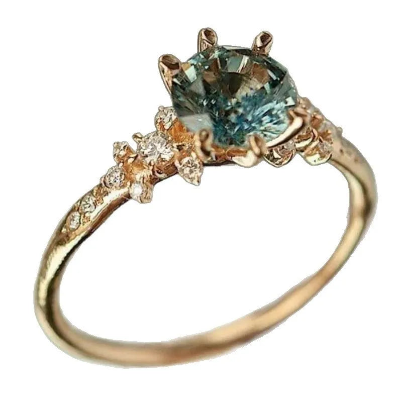 Gold geometric claw ring with square pattern and zircon stones on a grey background.