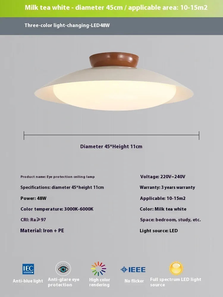 Modern minimalist flying saucer design ceiling lamp in cream yellow on a white ceiling.