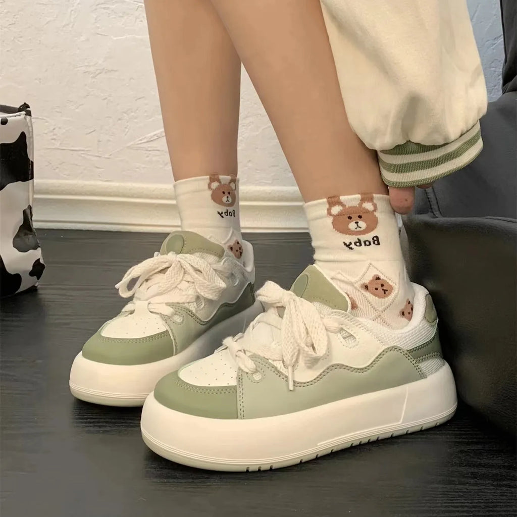 Green women's flat casual sneakers with a round toe and breathable PU mesh upper.