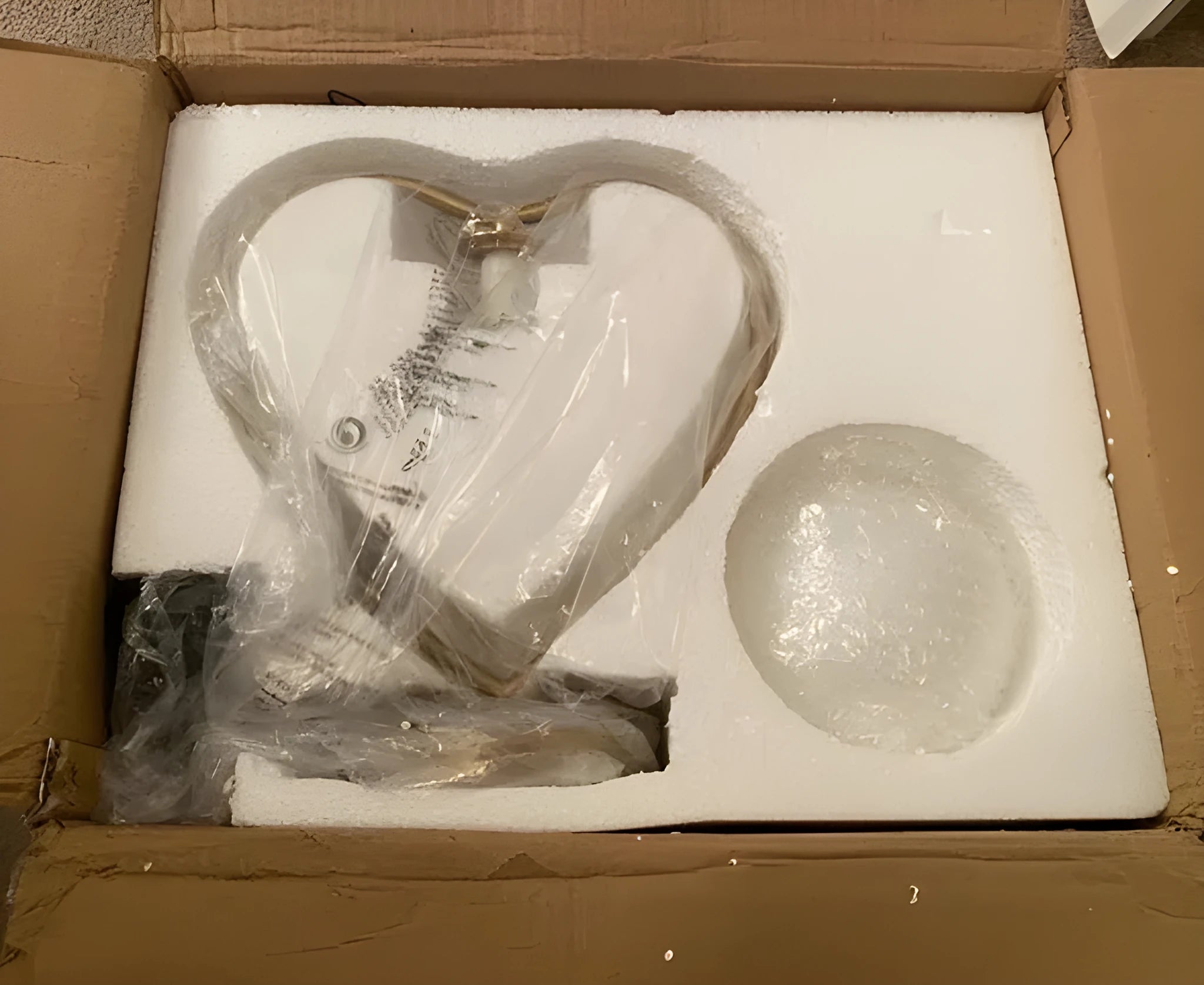 Clear acrylic heart shaped LED table lamp with warm white light on a surface.