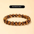 Close-up of a single-circle beaded Buddha rosary bracelet with tigereye dzi patterns on brown beads.