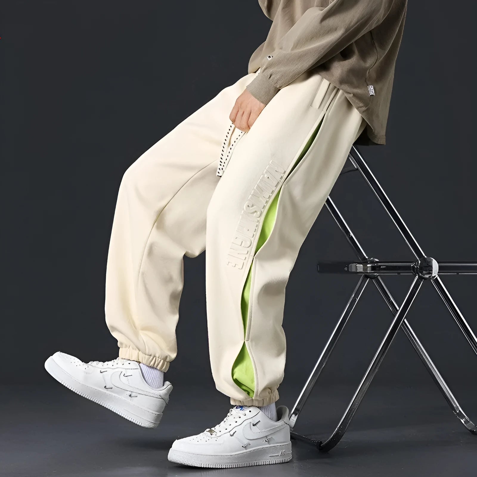 Men's loose grey green cotton trousers with ankle banding and stitching print detail on the leg.