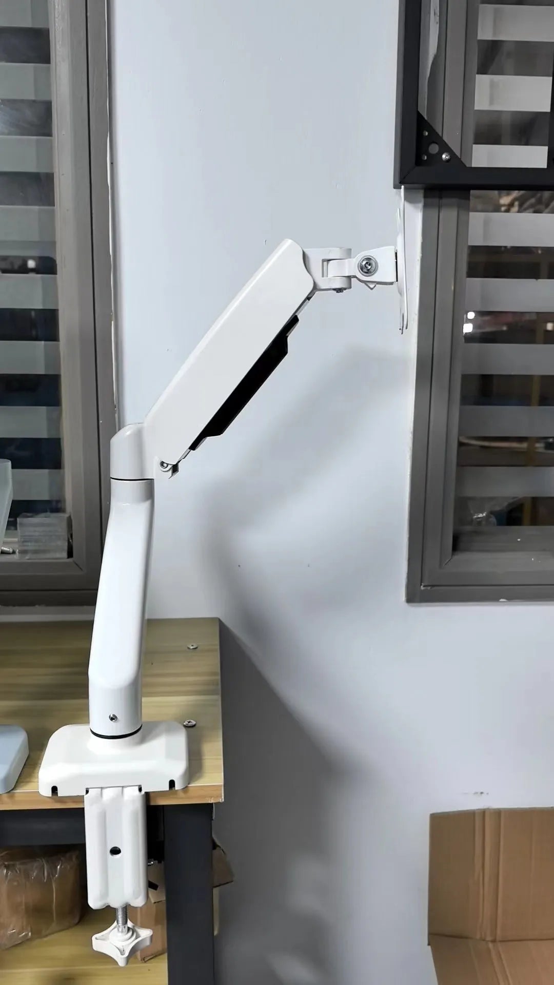 Black rotating telescopic LCD screen bracket on table with adjustable height and angle