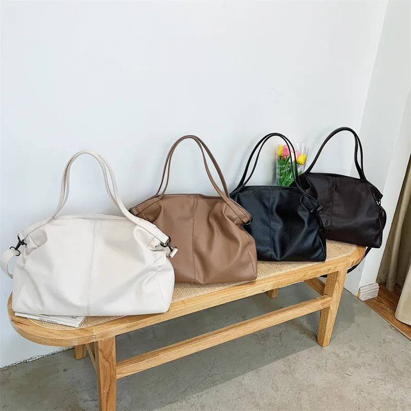 Large soft PU leather messenger bag with adjustable strap in black, shown open with internal pockets.